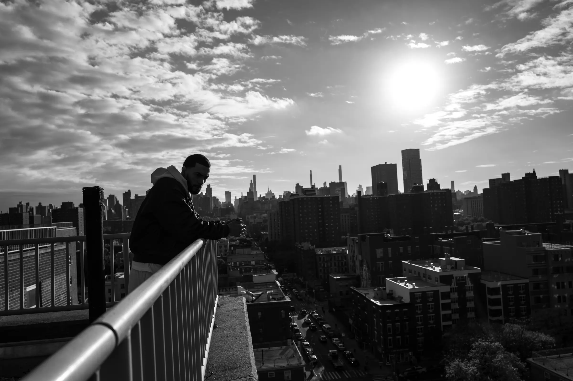 A figure on a New York rooftop at sunrise